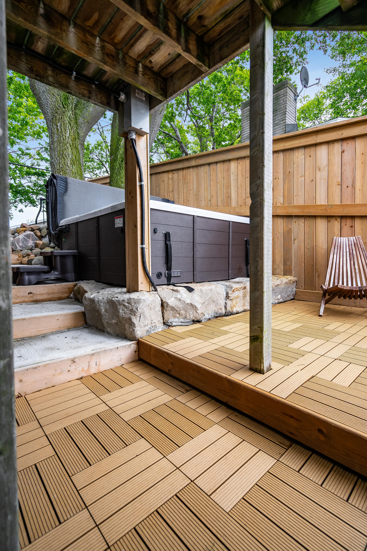 Modern outdoor hot tub nestled in a private, tree-lined backyard.
