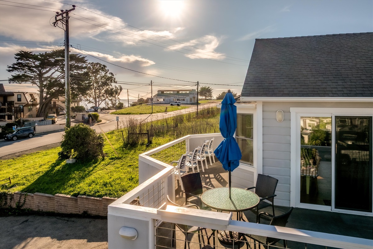 View of the spacious deck with plenty of chairs and dining table overlooking the water.