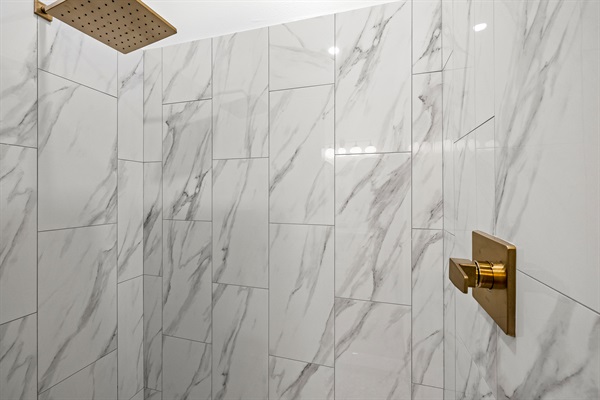 Spacious shower with rainfall shower head.