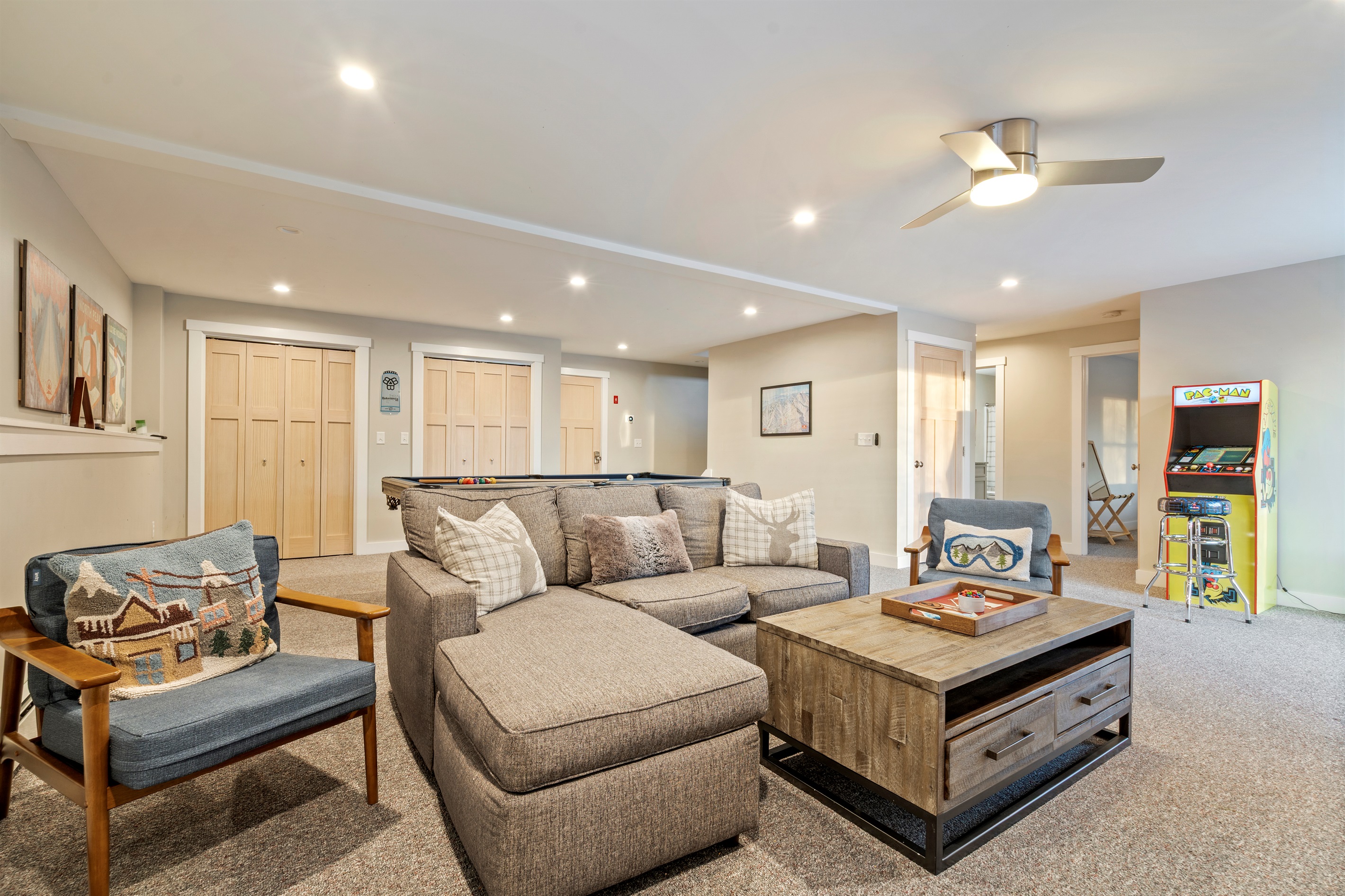 Basement game room featuring a cozy lounge and large TV for movie nights.
