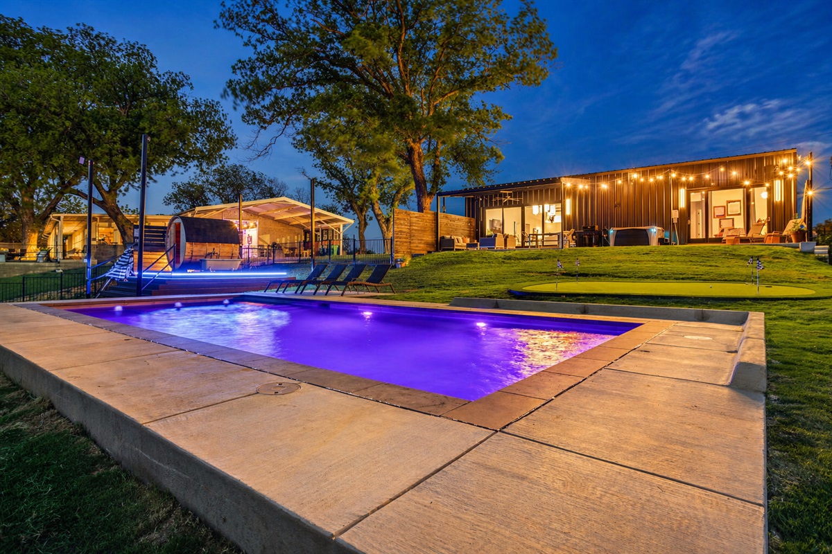 Private pool, sauna, hot tub, and putting green at The Noir, a luxury lakefront barndominium vacation rental on Lake Granbury, Texas.