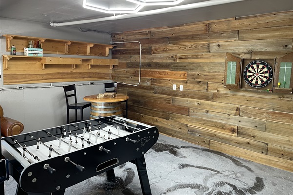 foosball table, darts and chess table located in garage