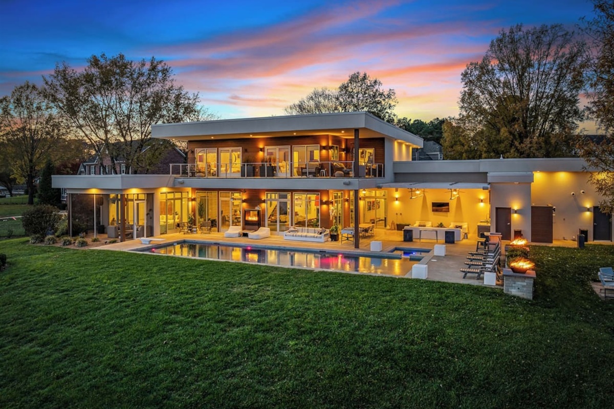 The house lit up at night with firebowls and fireplace going as well!