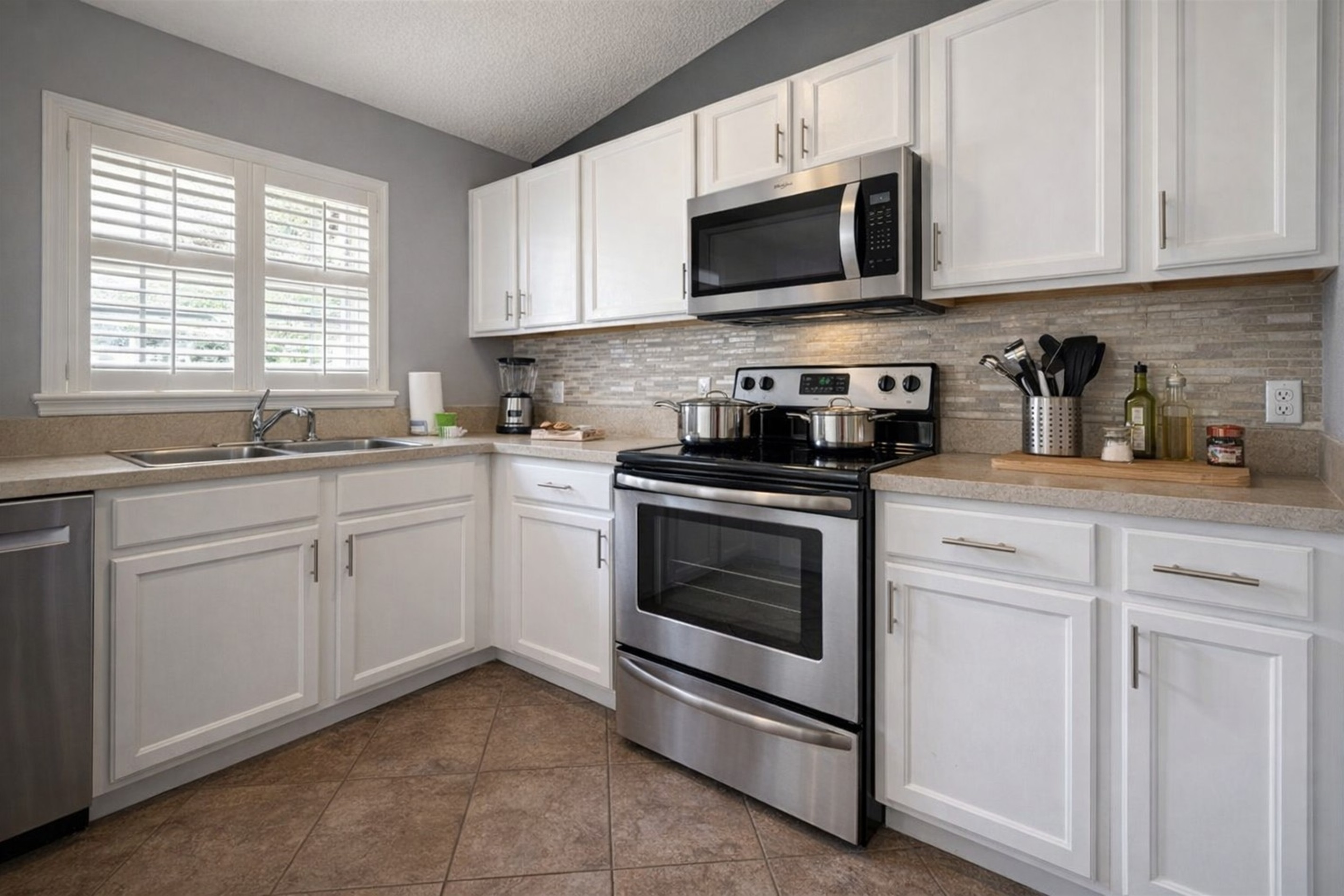 Modern kitchen with stainless steel appliances and ample natural light
