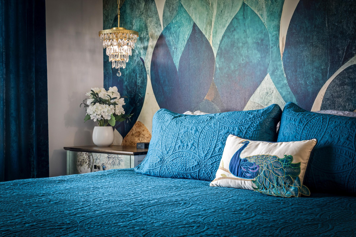The king bedroom combines rich colors, custom artwork, and soft textures to create a space that feels both cozy and luxurious.