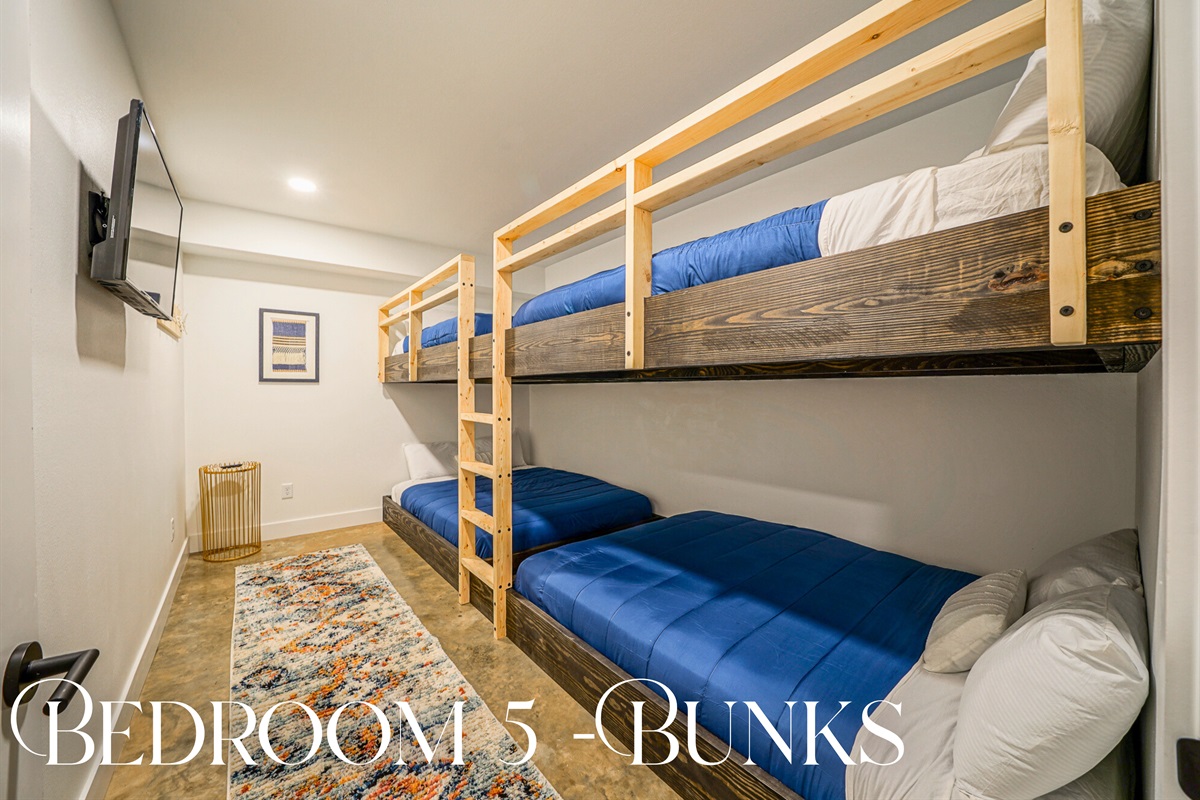 Perfect for kids, cousins, or late-night chats — this bunk room features four twin beds, cozy linens, and its own TV for entertainment.