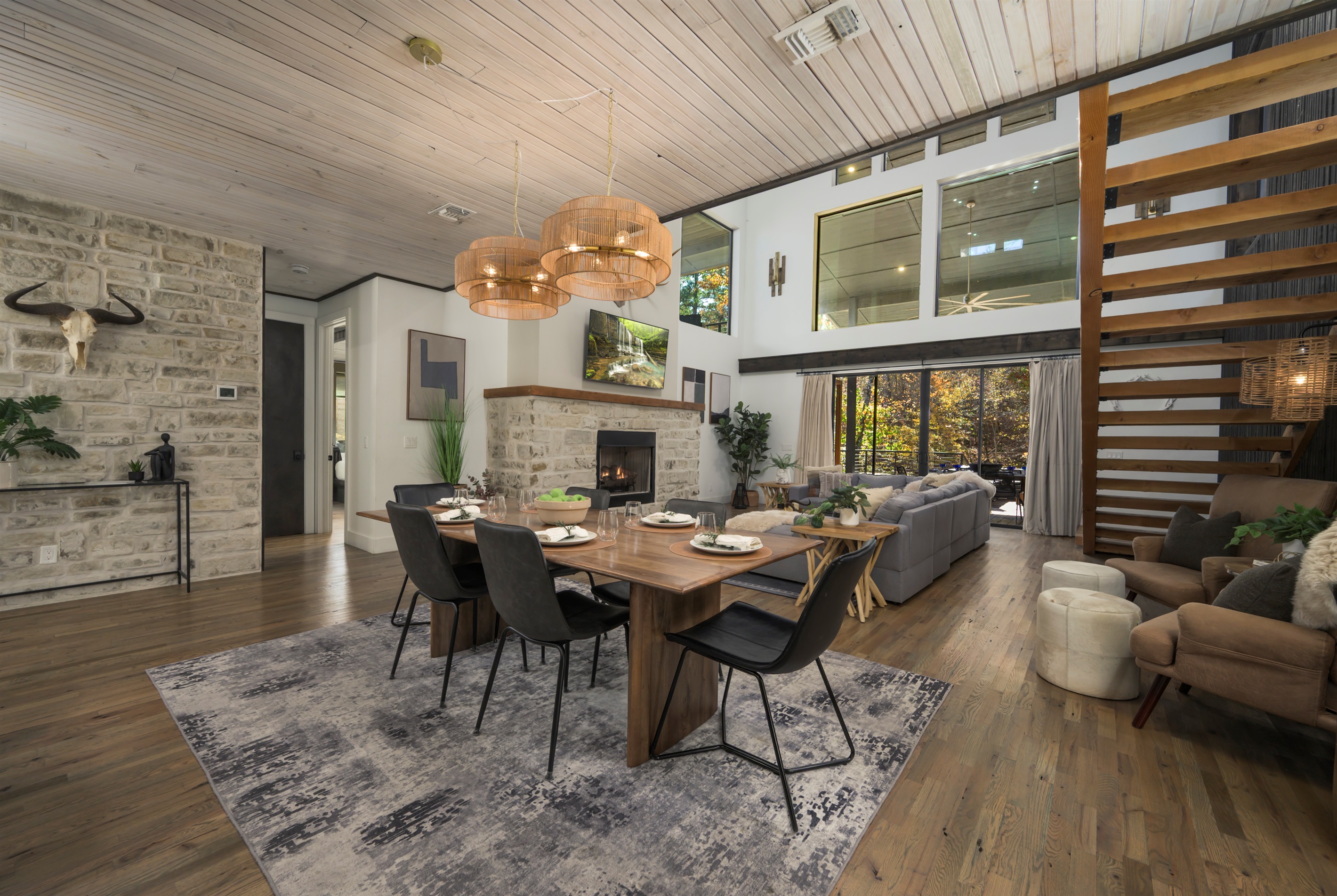 Modern cabin elegance: layered textures, warm wood tones, and a stone fireplace create a beautifully balanced interior 