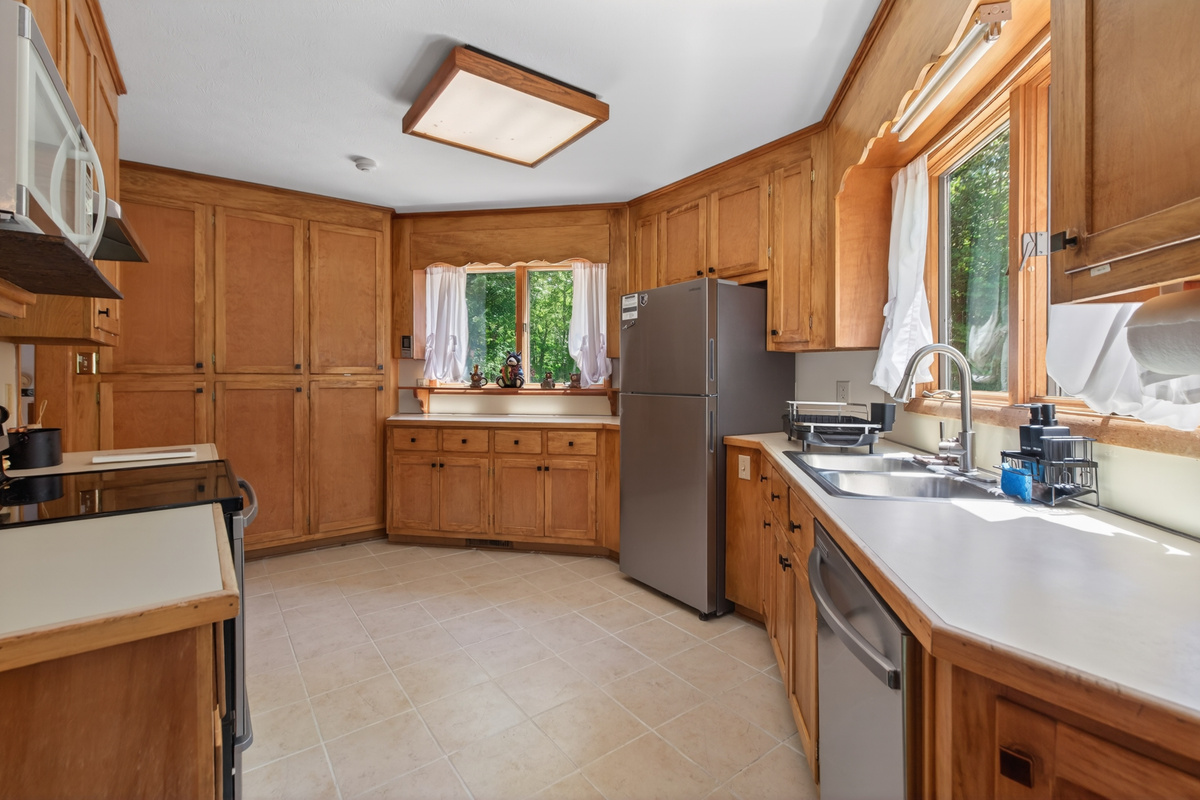Kitchen: Bright wood cabinets and sunny views create a delightful space for culinary adventures!