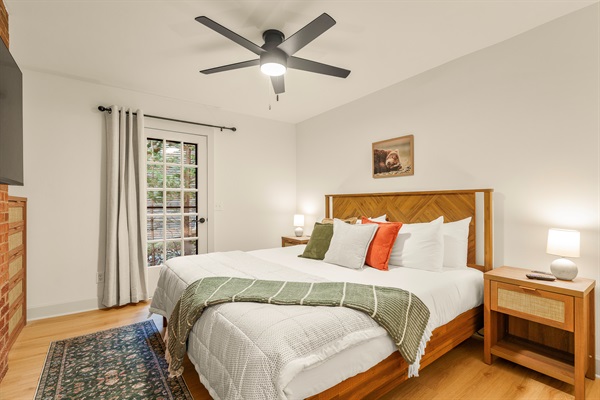 Main floor "master" with king-size bed, walk-in closet, full bathroom adjacent to the space, power charging nightstands, and private access outside. 