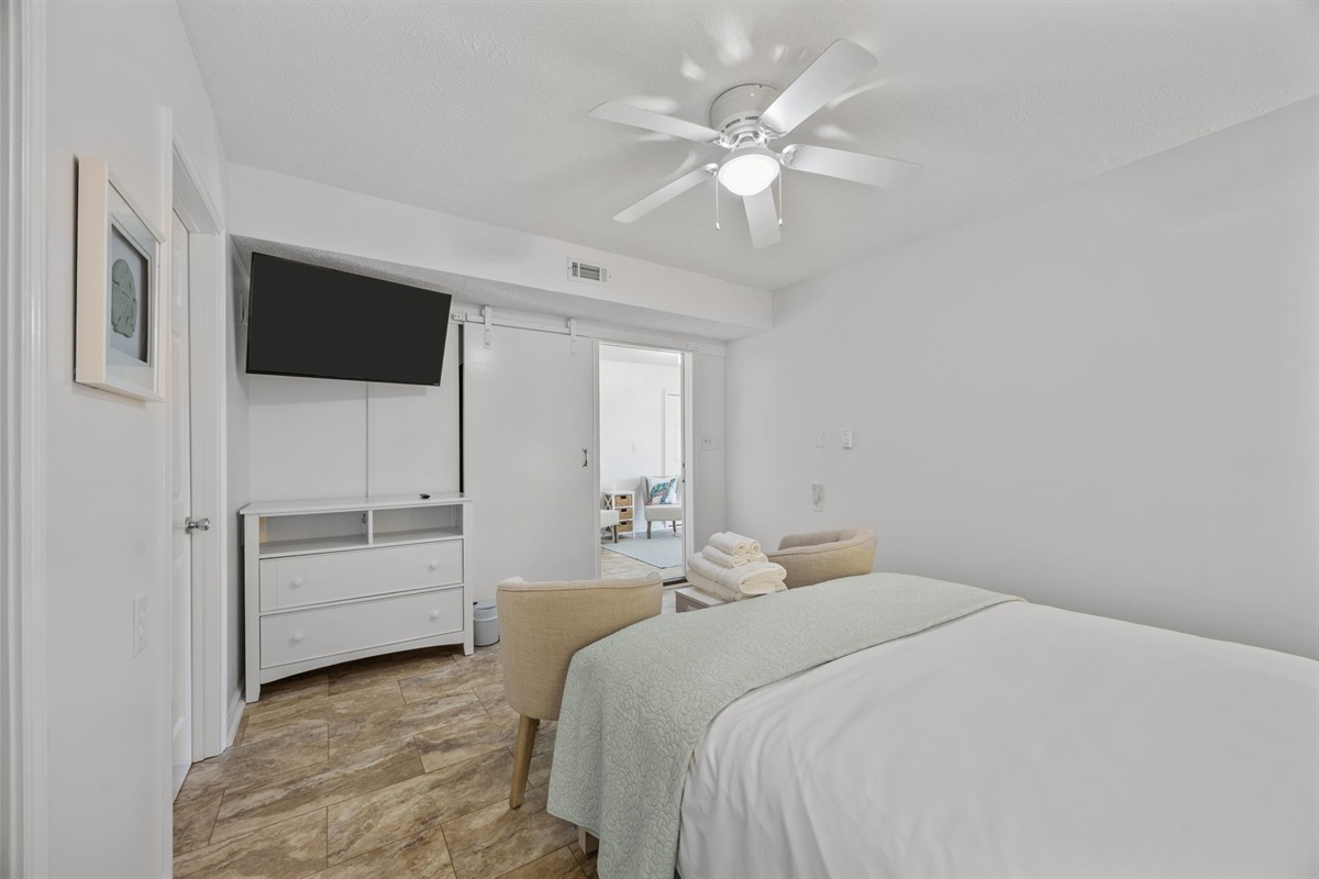 Ground-level bedroom with sliding doors leading to the sitting area and entry space, offering added privacy and convenience