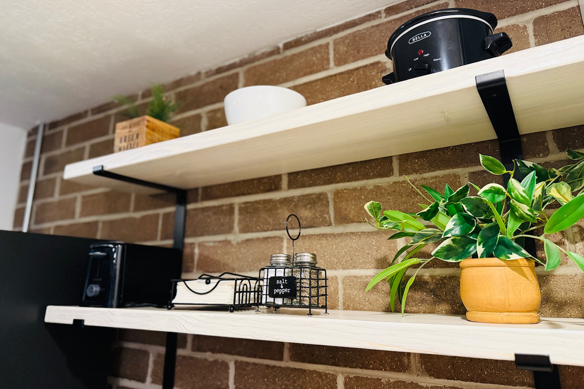 Open shelving keeps small appliances and serving pieces readily accessible.