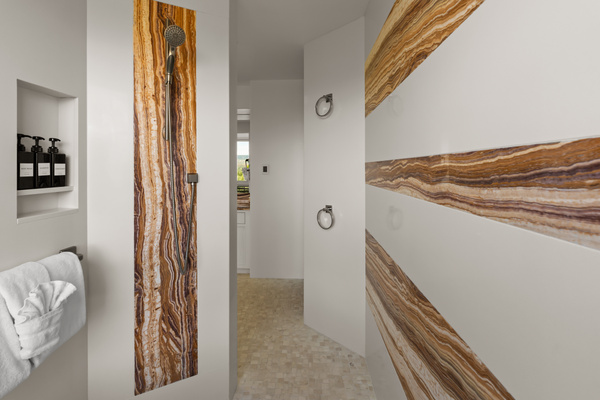 Close-up of the bathroom’s striking accent wall, highlighting rich earthy striations and modern clean lines.
