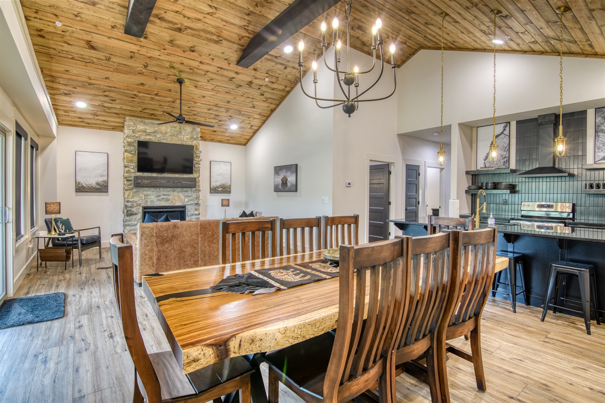 Open dining, living, and kitchen with cathedral ceilings.