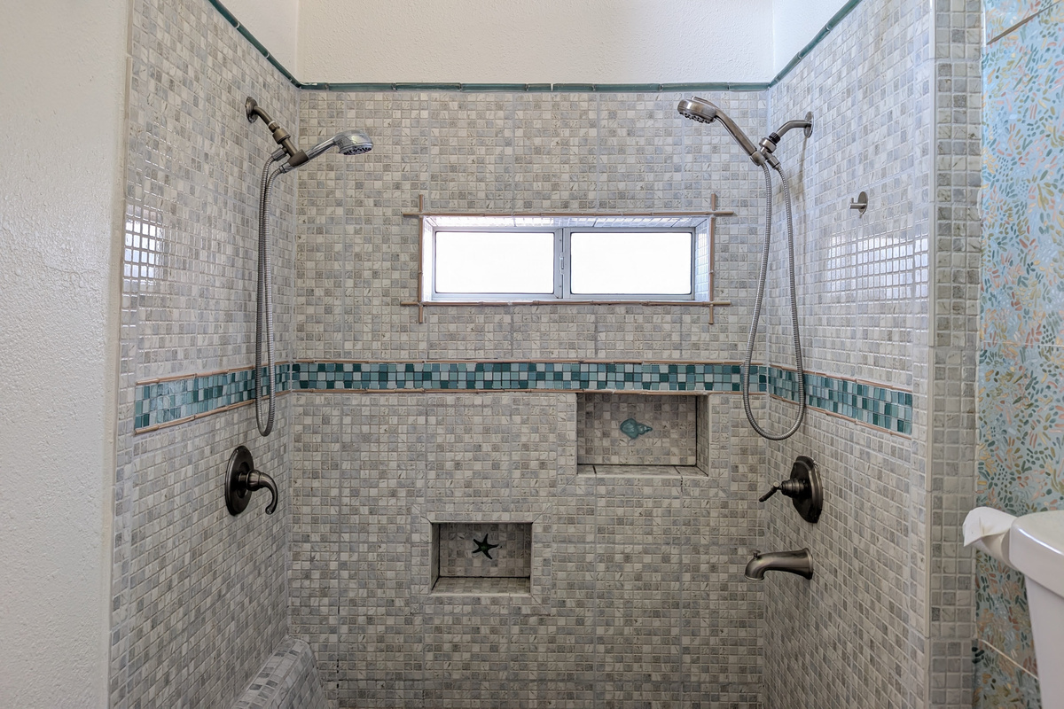 Spacious walk-in shower with dual showerheads. 🚿