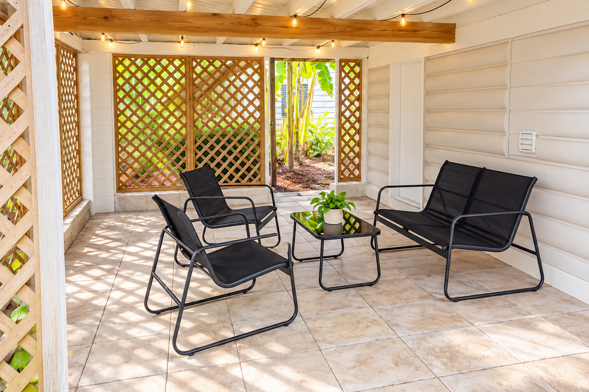 Covered patio with string lights, lattice walls, and cozy seating for gatherings.