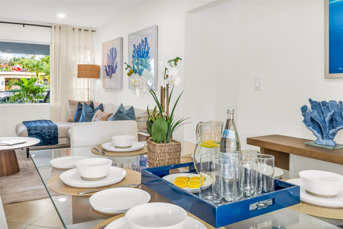 Enjoy meals together in this stylish dining space with seating for six, ocean-inspired artwork, and plenty of natural light flowing in from the adjoining sunroom.