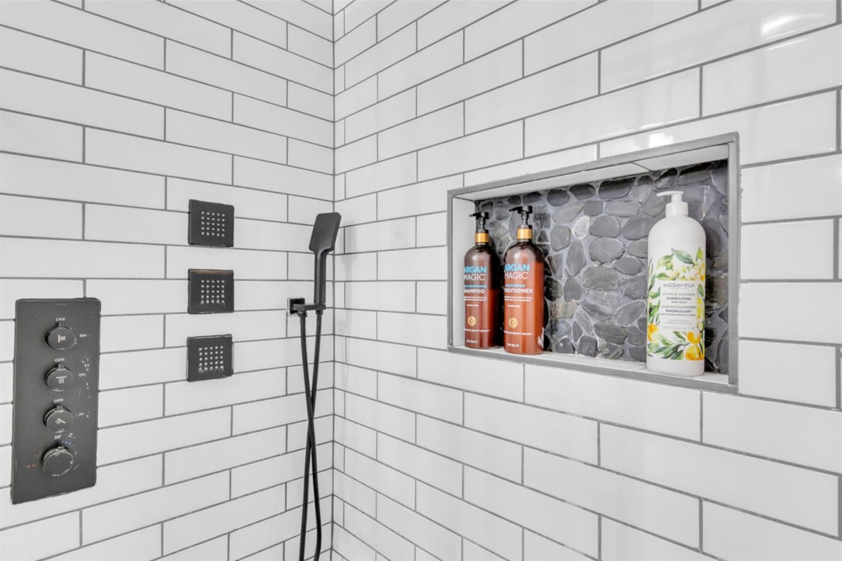 Bold, modern, and spa like master bath features an industrial style luxe shower set up