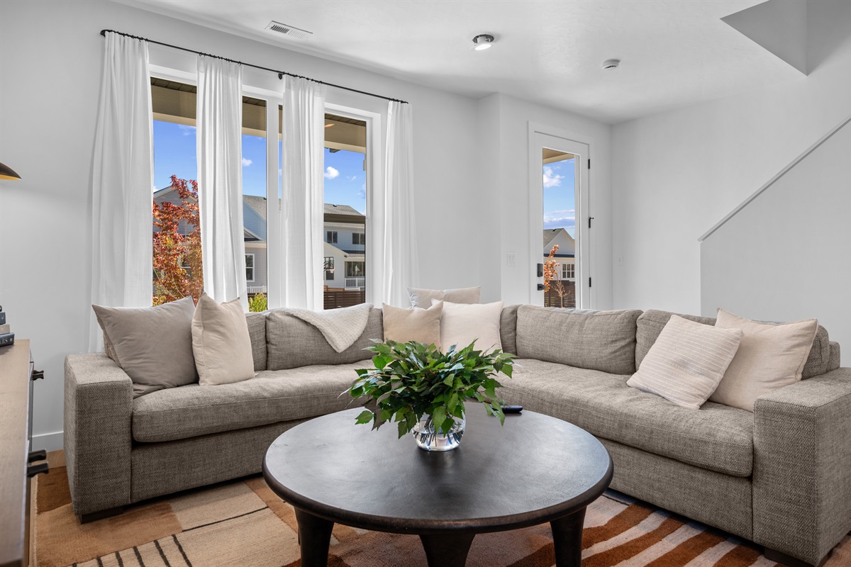 Natural light floods through large windows, creating a warm and welcoming atmosphere with stunning neighborhood and mountain views.
