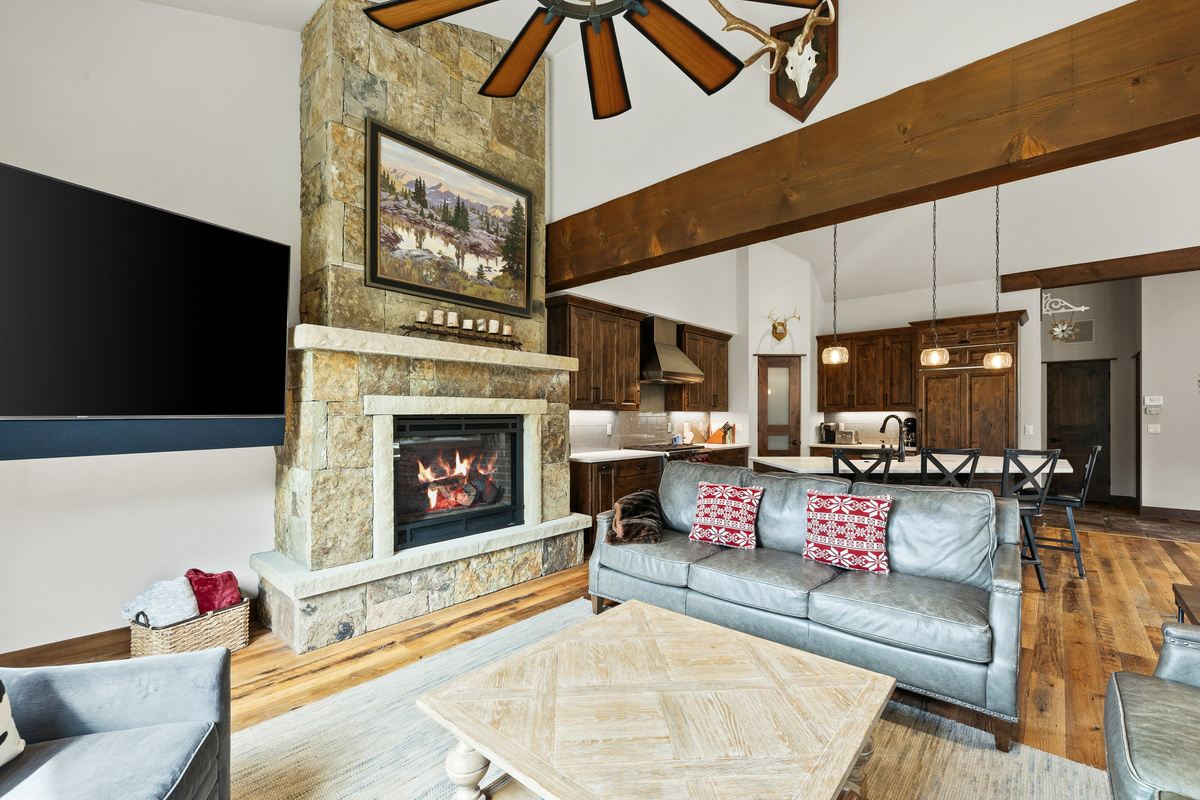 Main living area with gas fireplace, large tv, comfortable seating and open concept to dining and kitchen
