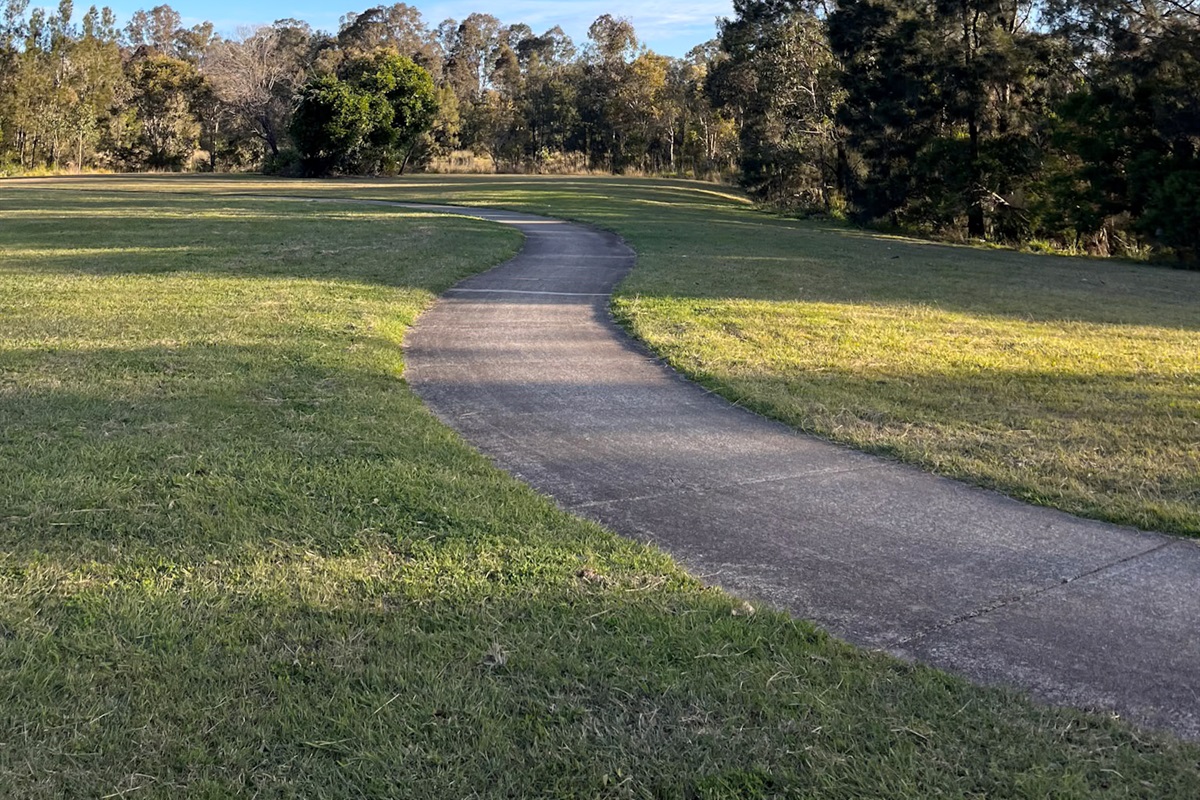 The nearby path gives the stay an easy outdoor route, linking grassed parkland, trees and local lake access.
