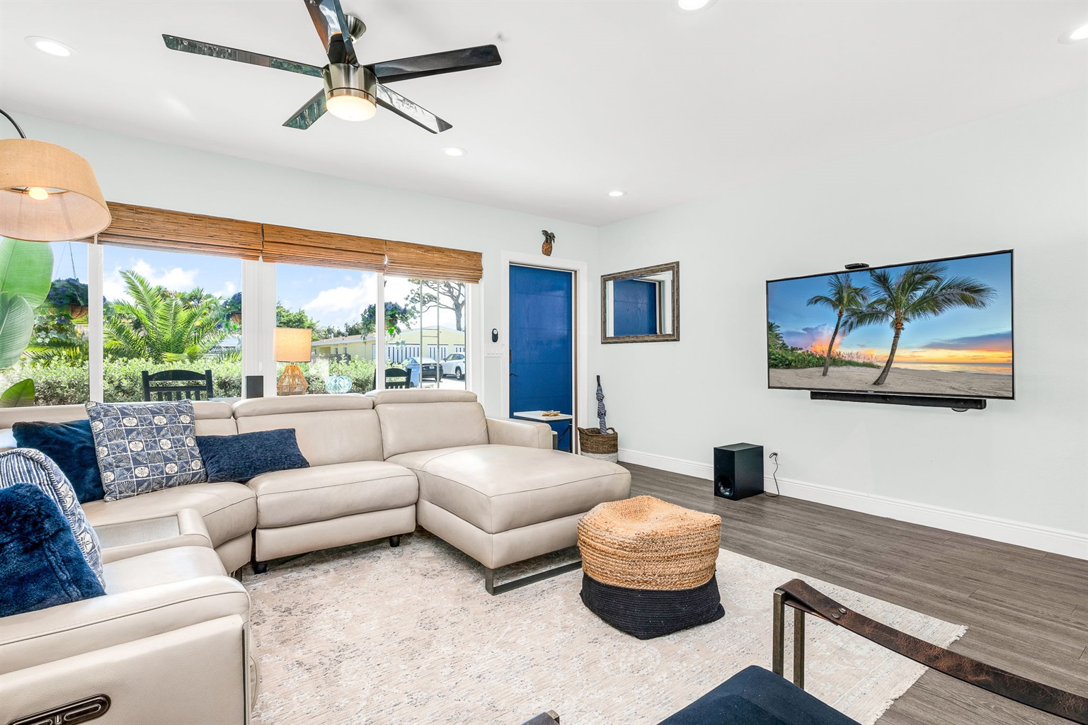 Bright, open-concept living area with modern, plush furnishings, seamlessly blending indoor comfort with outdoor living, and a relaxed coastal vibe - ideal for gathering with family and friends.  