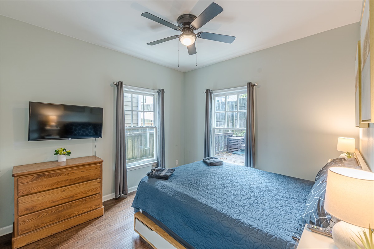 Bright and functional queen bedroom with entertainment and storage for your stay.