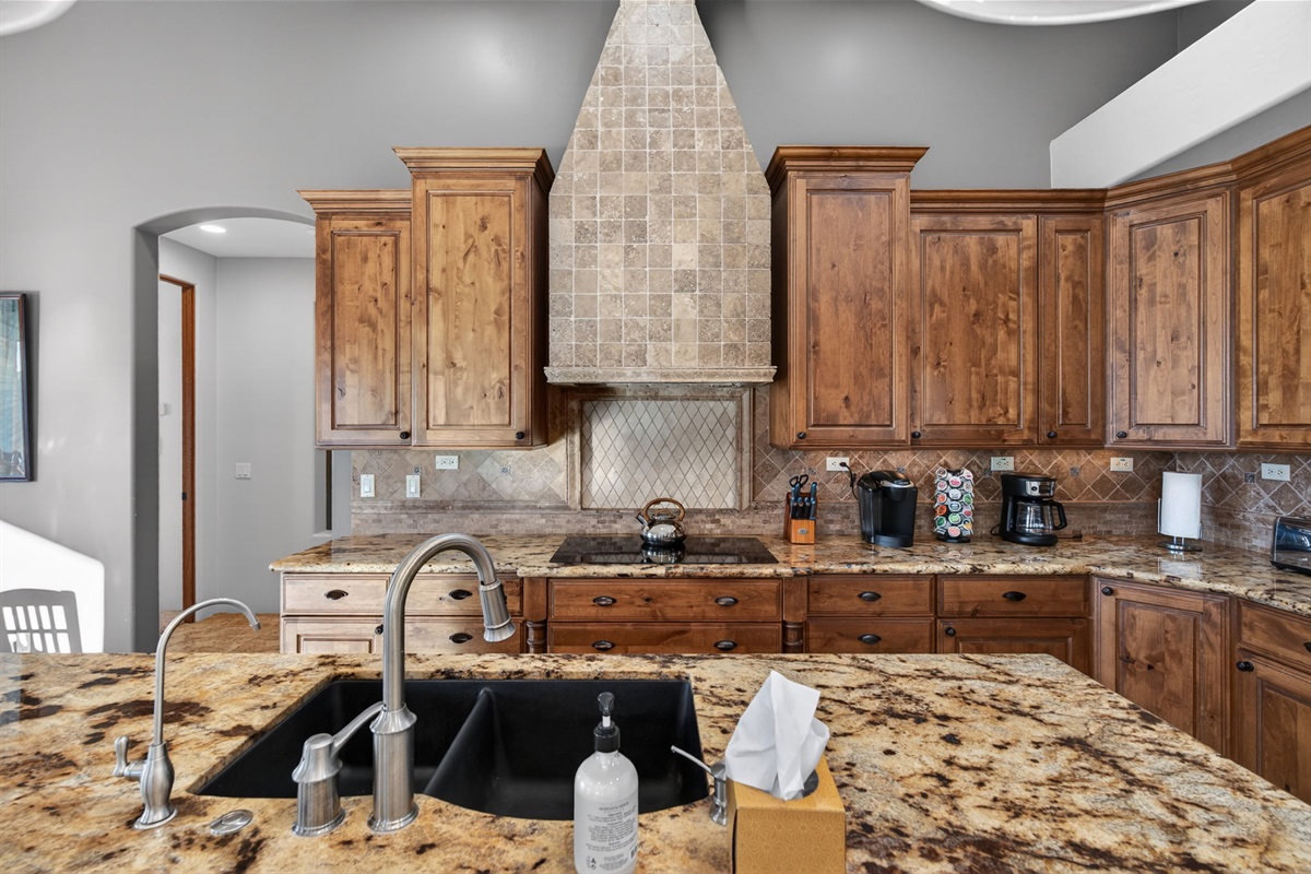 Chef-style kitchen with granite counters, custom cabinetry, and premium appliances ready for group meals and celebrations