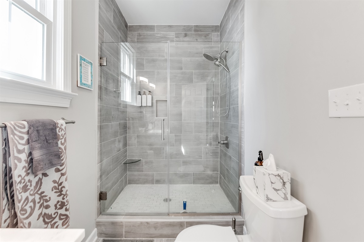Ensuite Bathroom 2: Refresh in the sleek glass shower with modern fixtures and natural light!