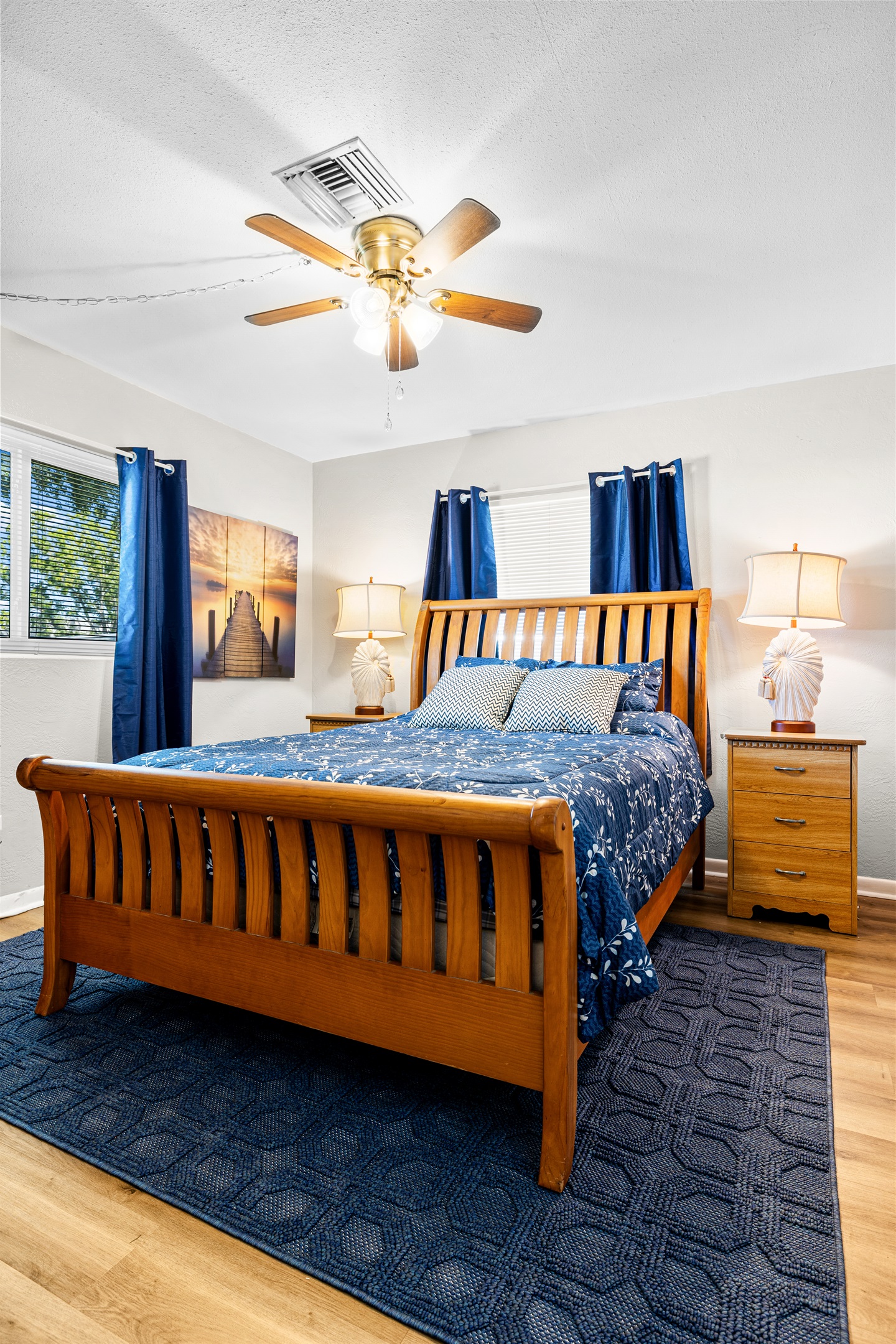 No Wake Queen Bedroom with Roku TV, a bookshelf, 2 nightstands, a dresser and two closet areas.