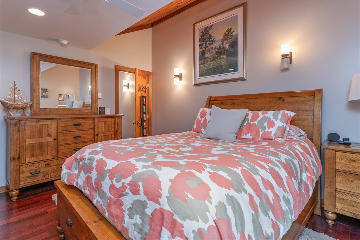 Cozy queen bedroom with warm lighting and nature views.