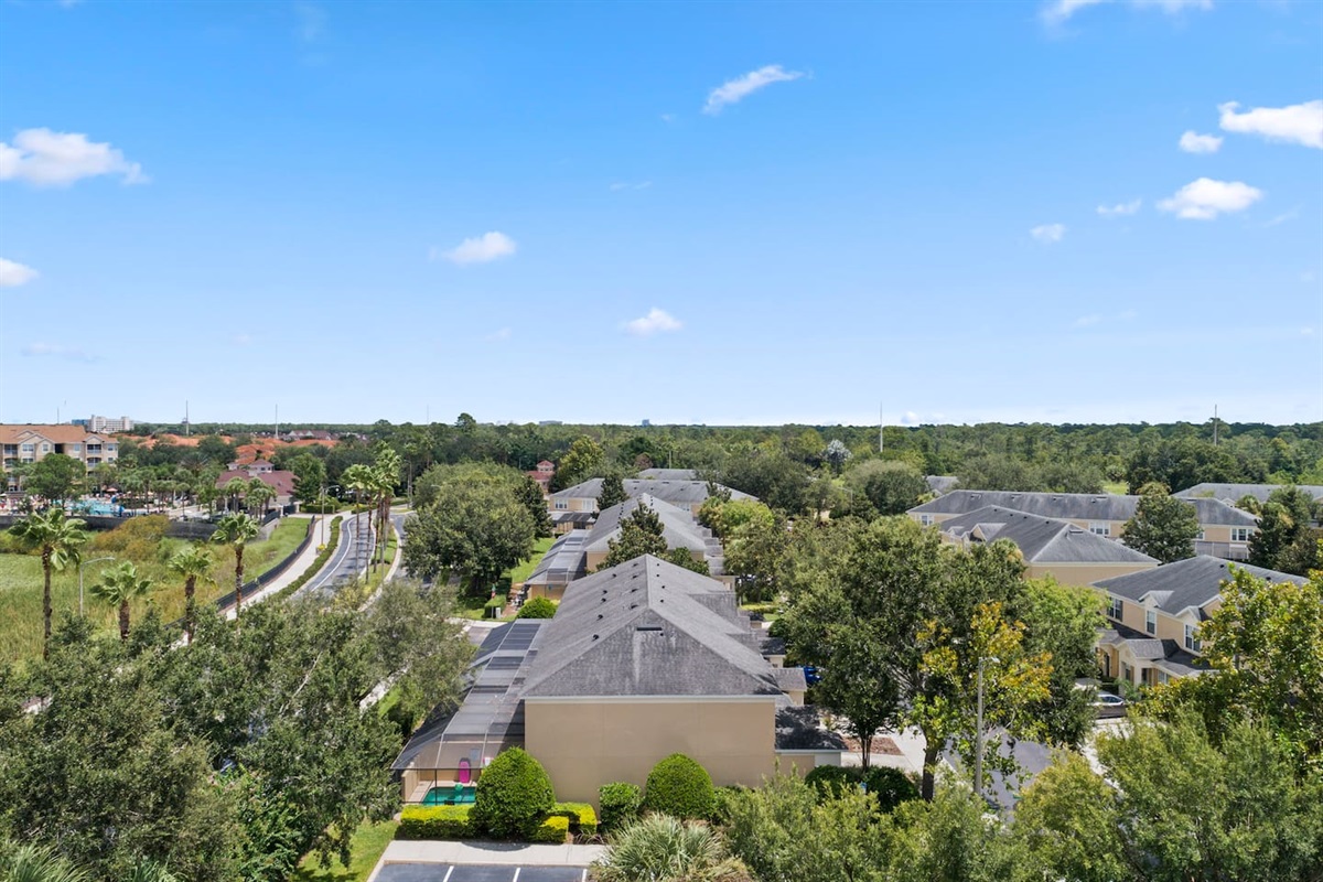Neighborhood aerial showcasing tree lined streets and homes.
