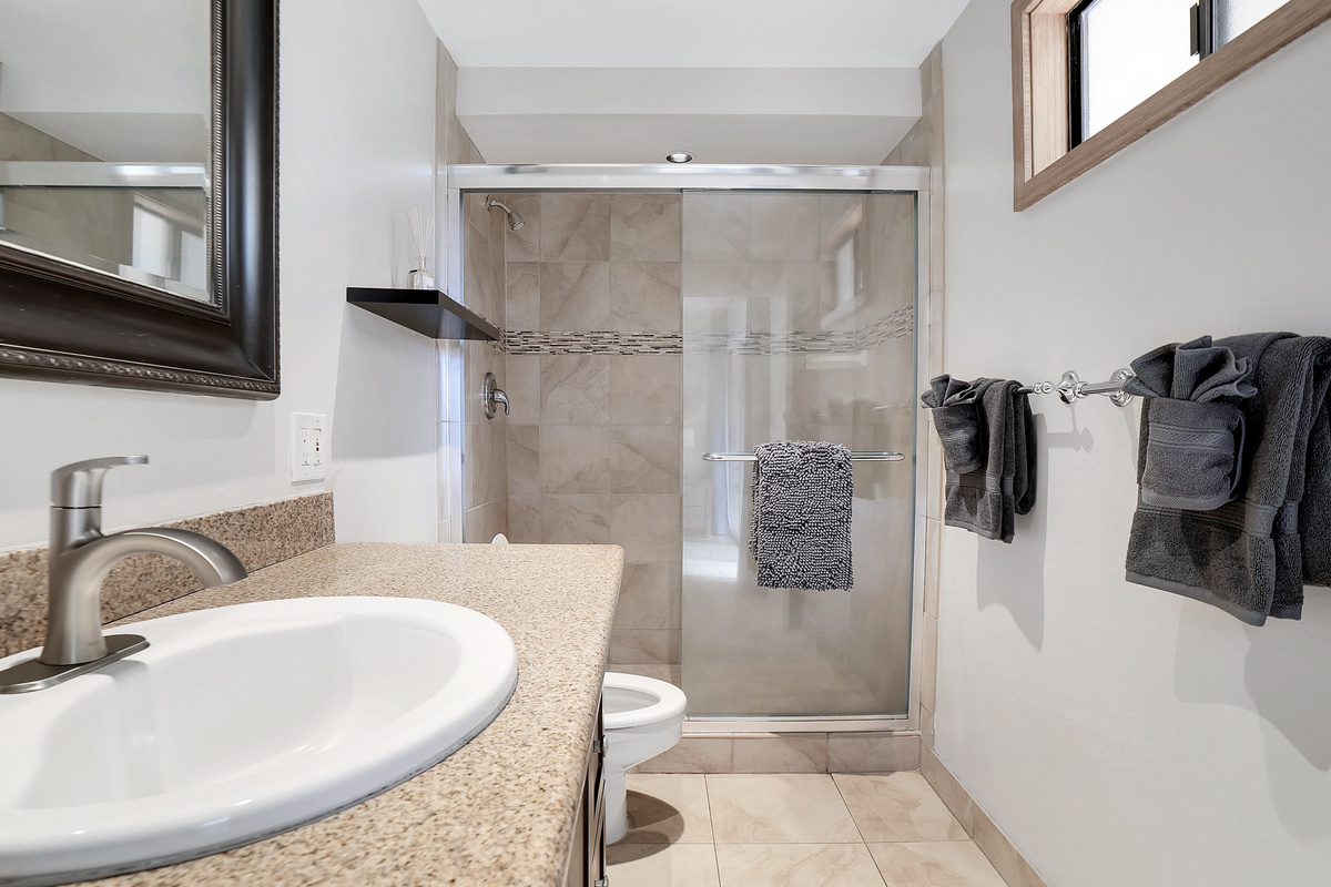Bright, modern primary bathroom with a walk-in tile and glass shower