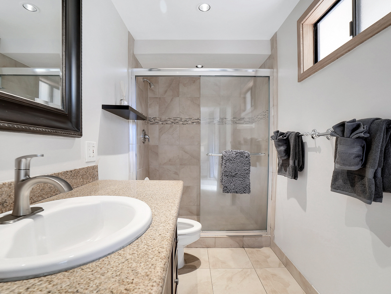Bright, modern primary bathroom with a walk-in tile and glass shower