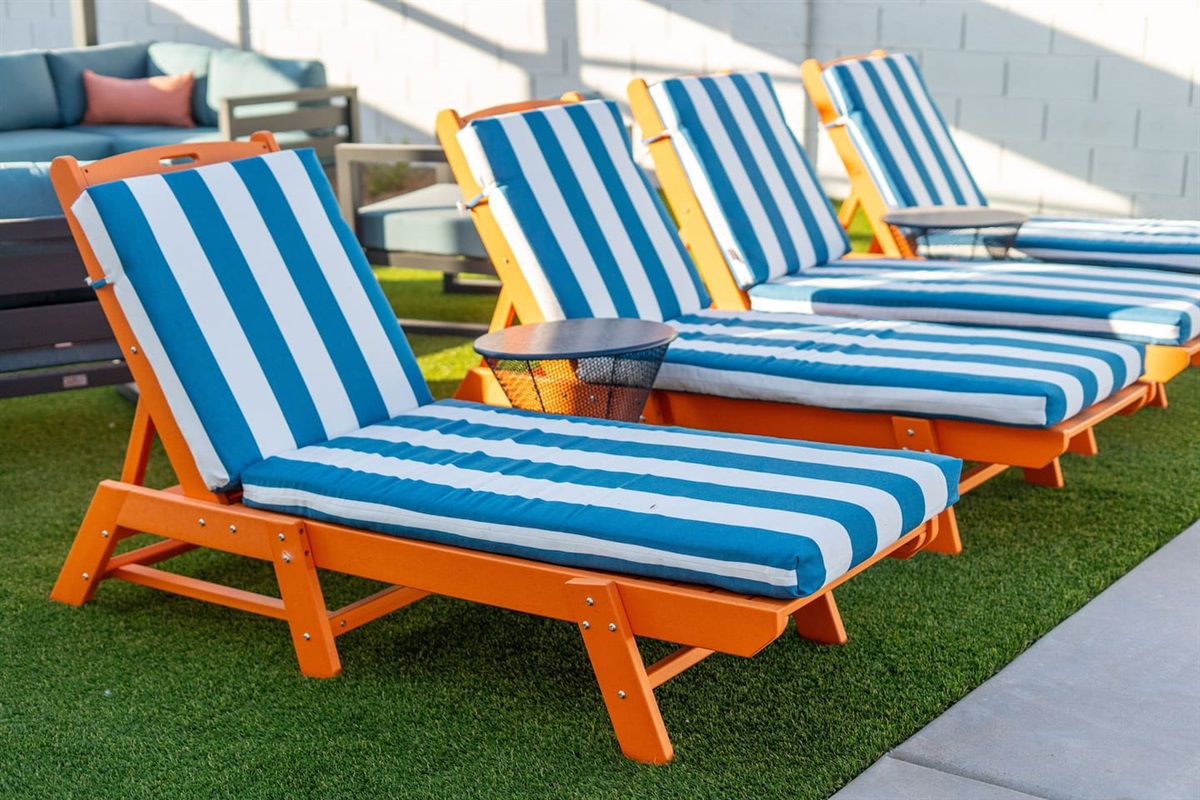 Bold orange frames with blue-and-white stripes bring a fun, beachy vibe to your poolside retreat.