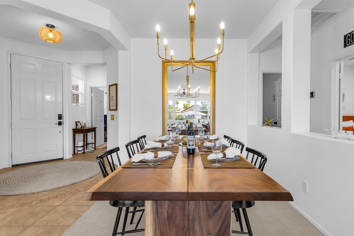Stylish dining room with a modern chandelier and a golden mirror adding warmth and elegance