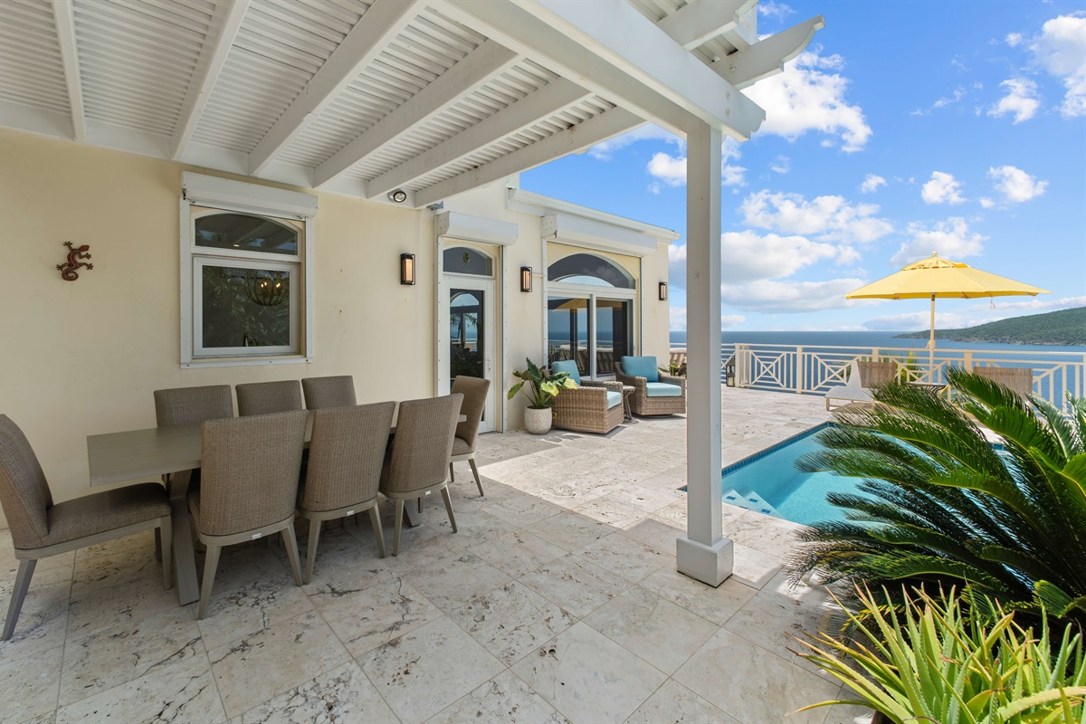 Covered patio with outdoor dining table and grill, perfect for sunset dinners or lazy brunches.