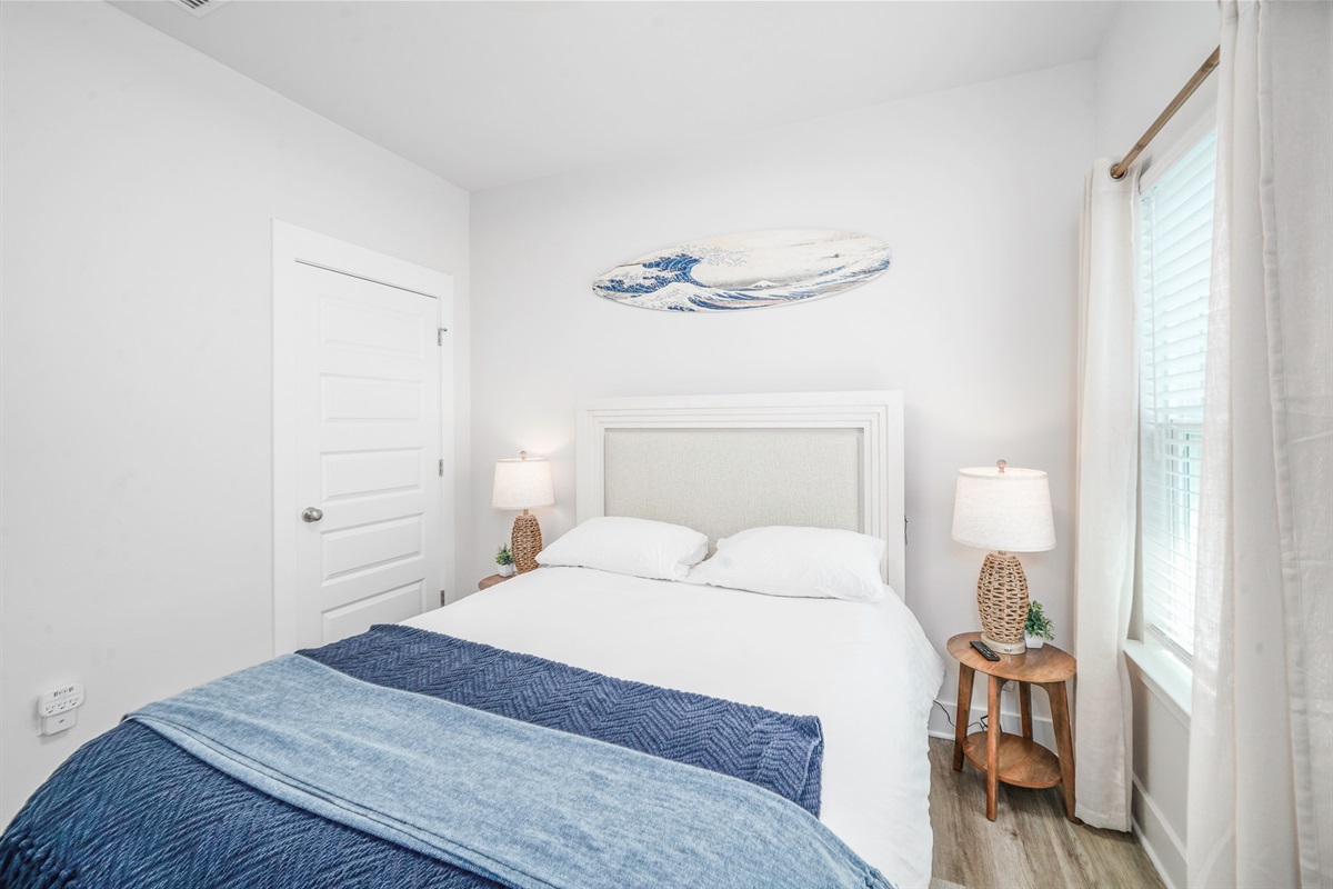 Bedroom 3: Queen bedroom, plush linens, ceiling fan, bedside lamps, wall art, and Smart TV.