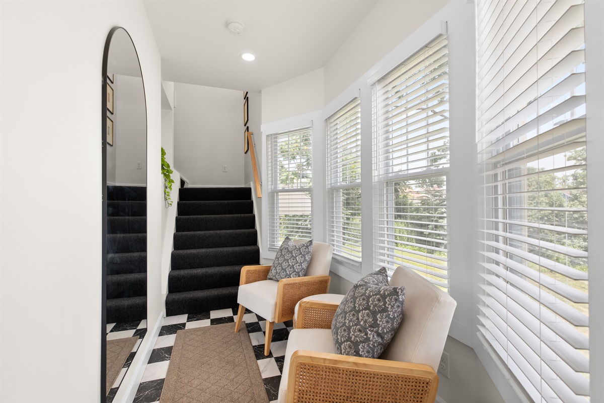 Bright entryway with large windows and cozy seating—perfect for enjoying natural light as you come and go.