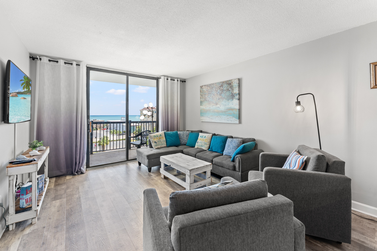 Comfy living room area with large TV and balcony access