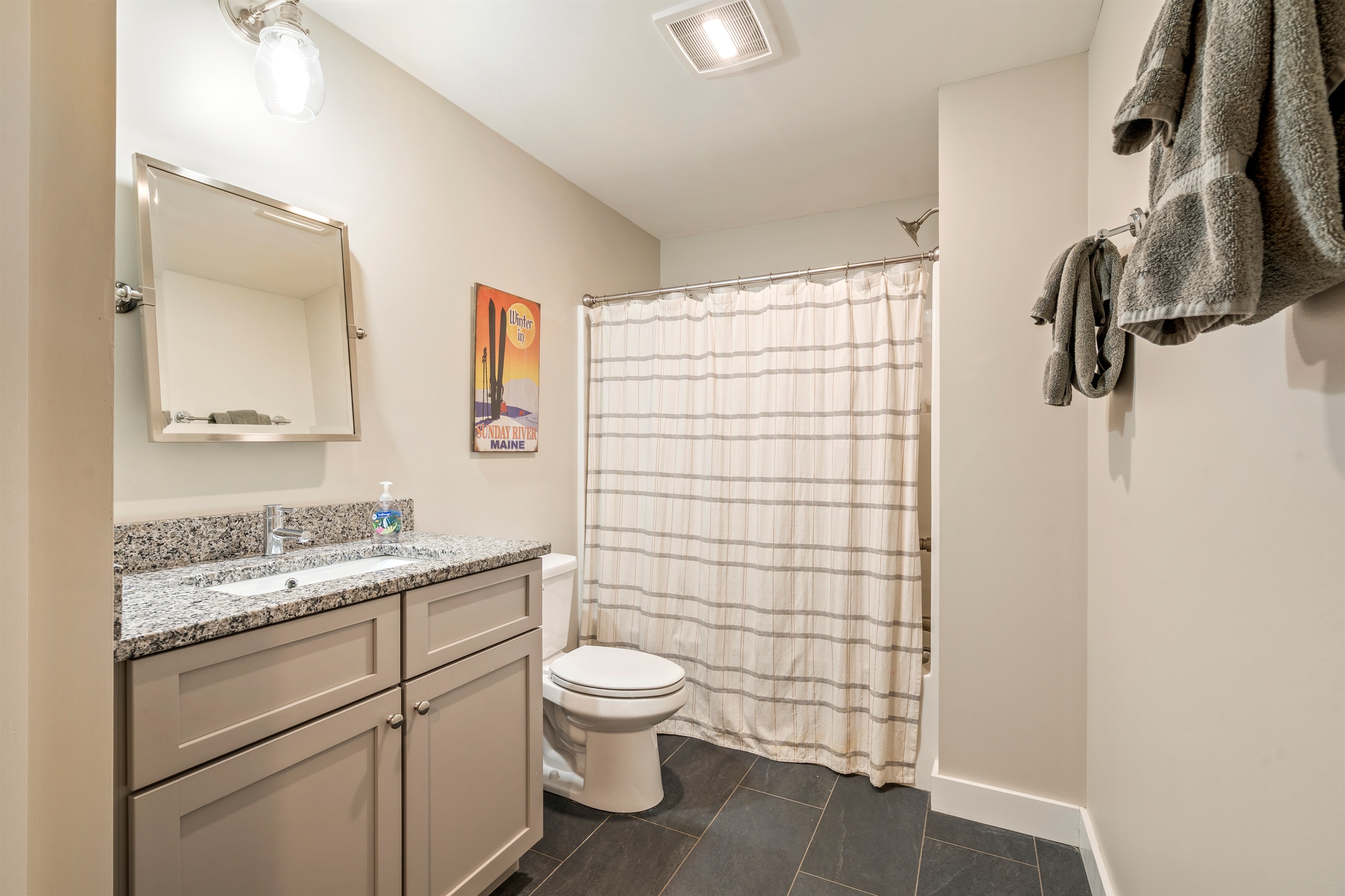 Basement bathroom featuring a full shower and tub combination with toilet.