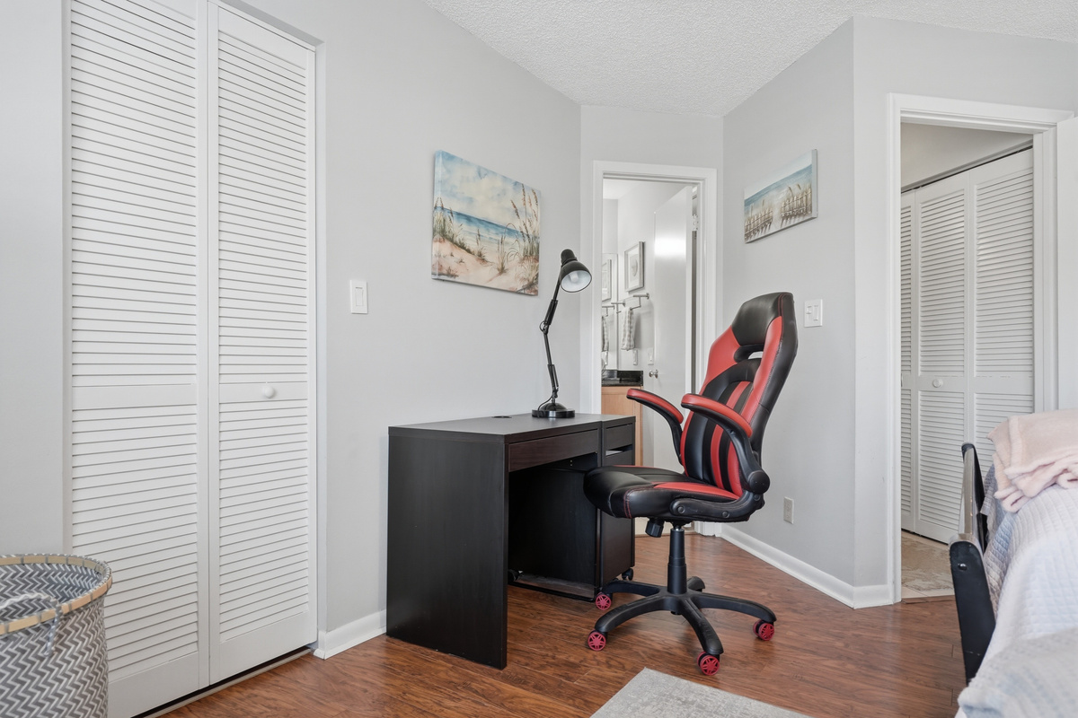 Unwind in the comfortable primary bedroom featuring a king-size bed, walk-in closet, ceiling fan, and easy access to the full bathroom. It's a peaceful retreat to relax and recharge after a day in the Florida sunshine.