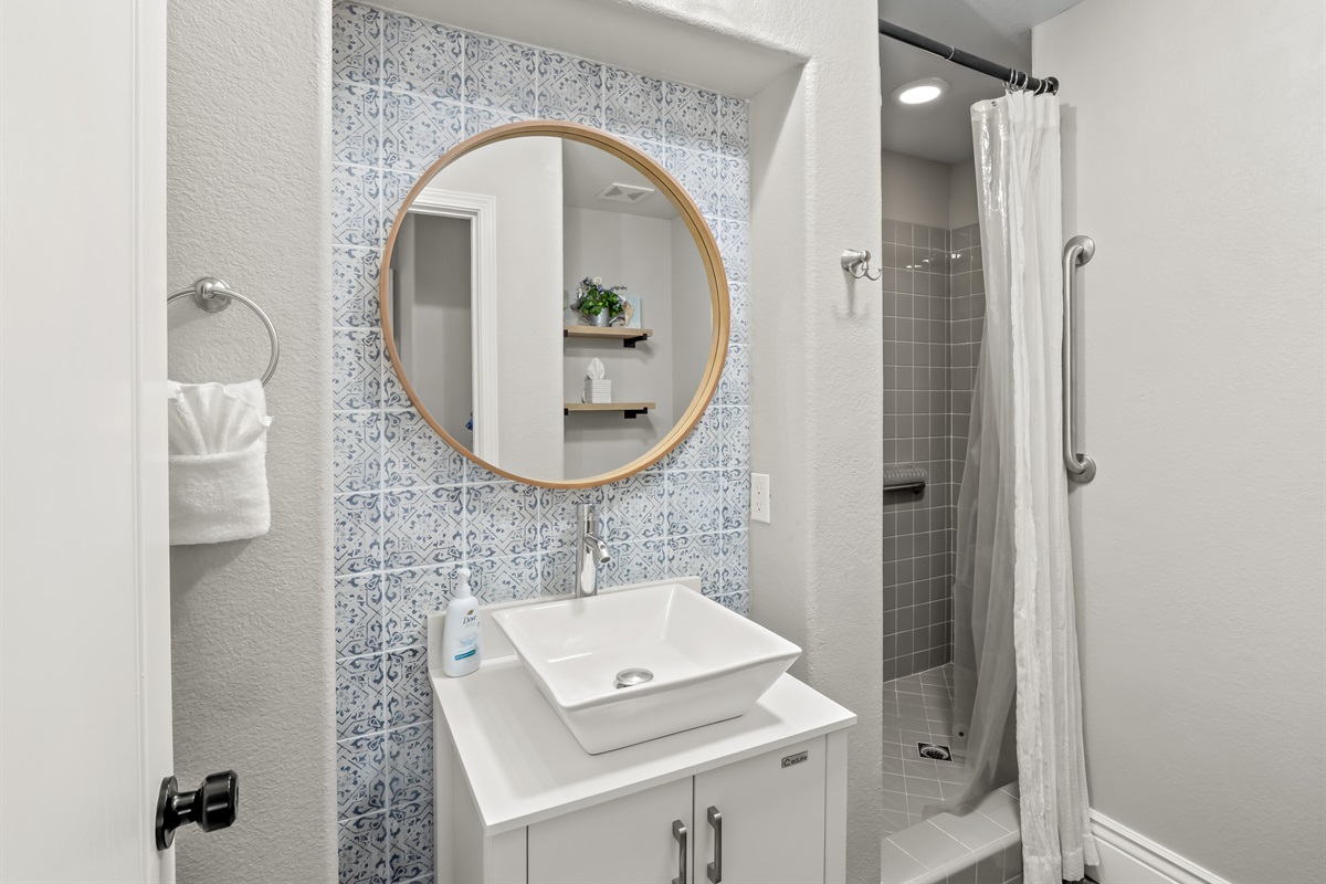 Bright and modern bathroom with walk-in shower, grab bar for added support, stylish vanity, and plenty of space for everyone to get ready comfortably.