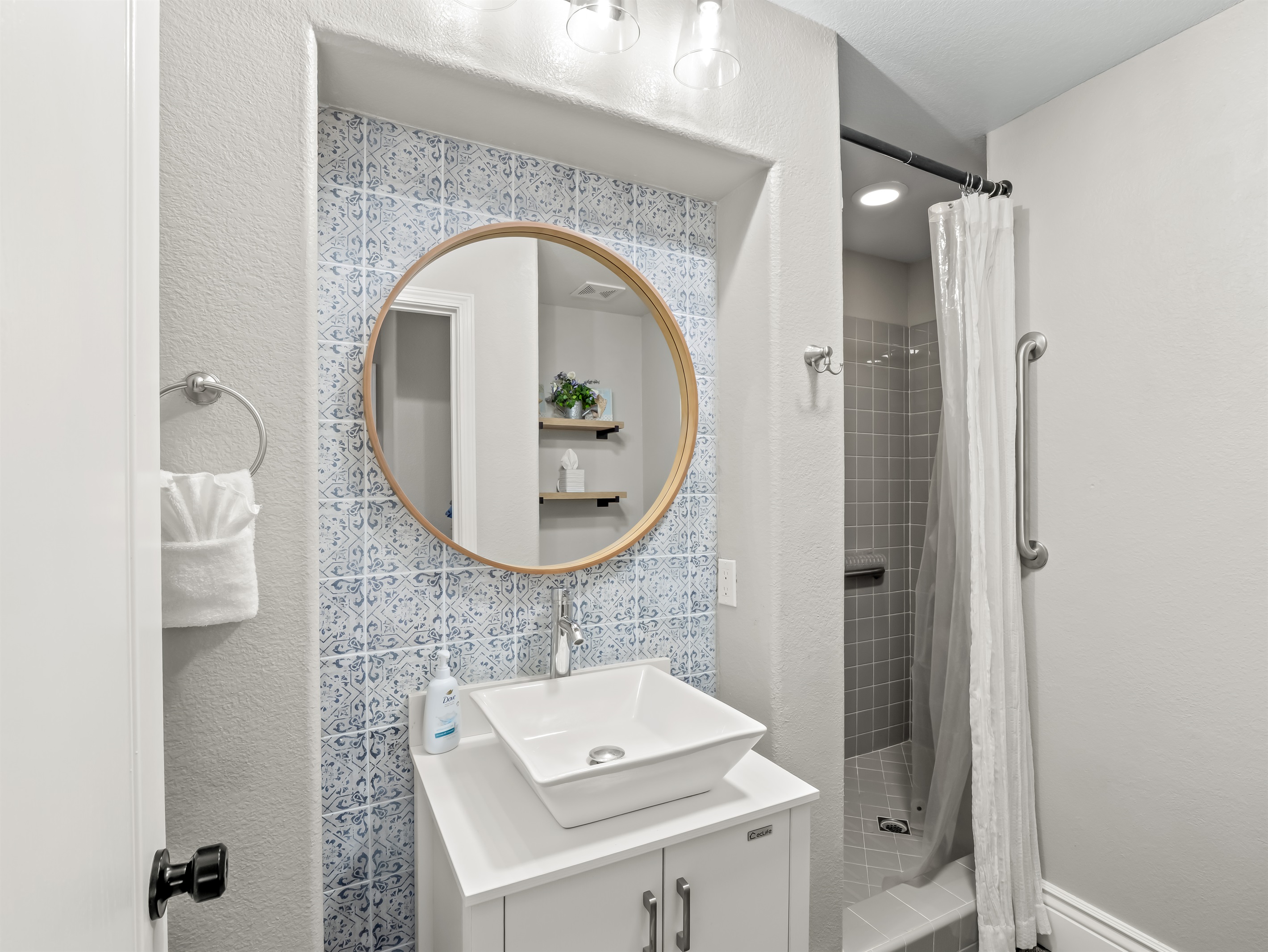 Bright and modern bathroom with walk-in shower, grab bar for added support, stylish vanity, and plenty of space for everyone to get ready comfortably.