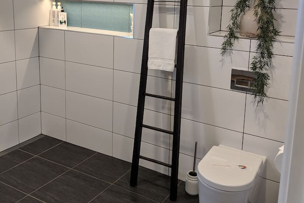 A high frosted window brings soft natural light into the bathroom at Aaron's Beachside Boat House while maintaining privacy around the shower area.