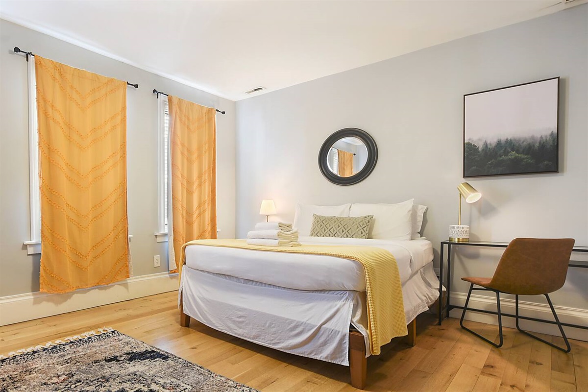 Comfortable queen-sized bedroom with a cozy workspace — ideal for rest and productivity.