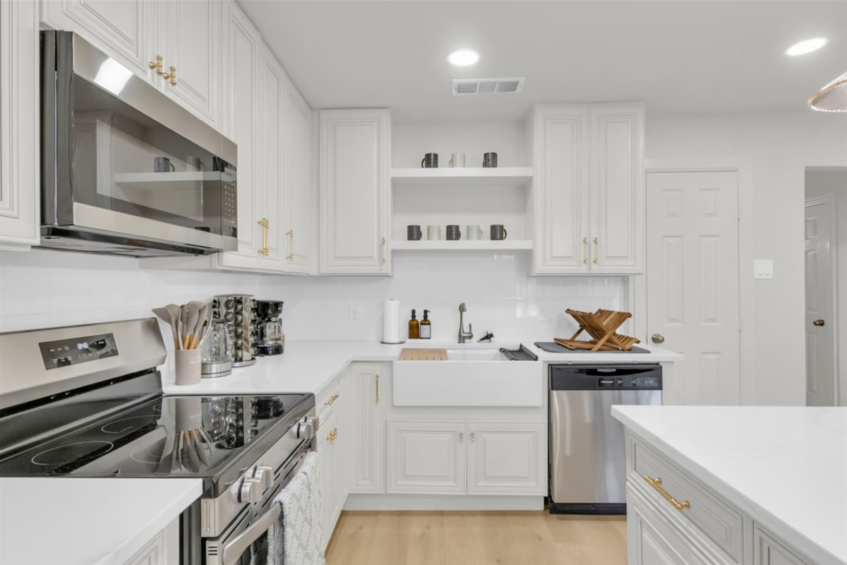 Upgraded Frigidaire fridge, oven, and microwave in a fully stocked kitchen. Includes coffee, toaster, blender, and essentials for everyday cooking.