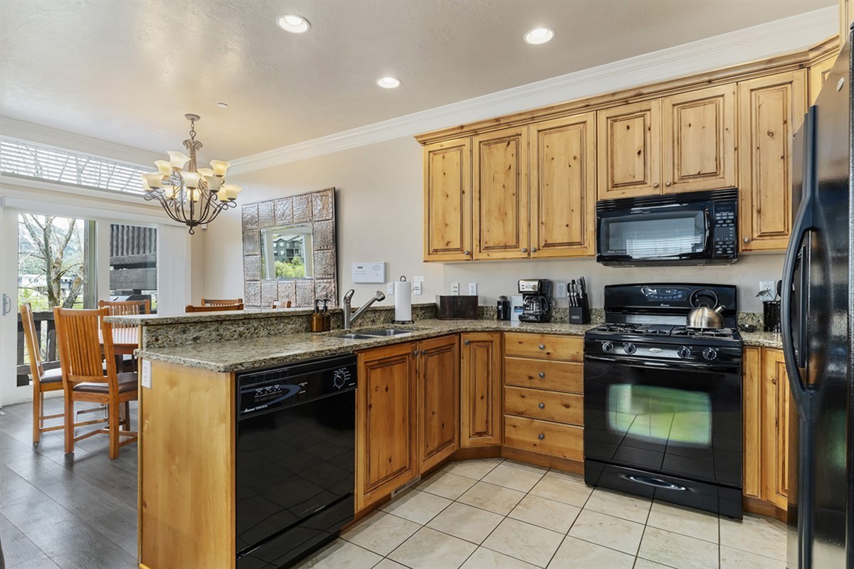 Well-appointed kitchen with granite countertops, appliances, and an adjacent dining space.