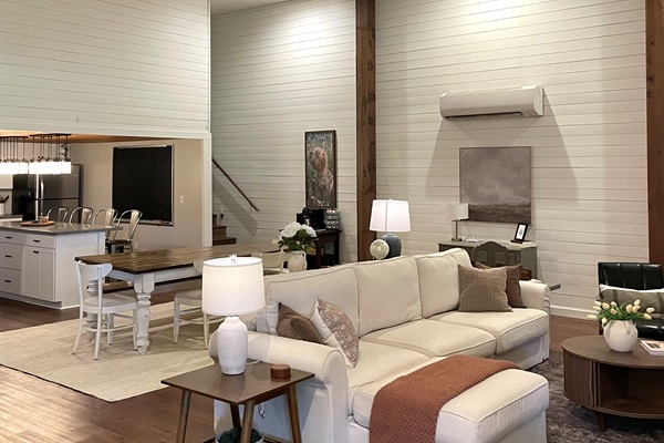 Open concept great room with high ceilings, cozy seating and a full kitchen, perfect for relaxing or gathering together.