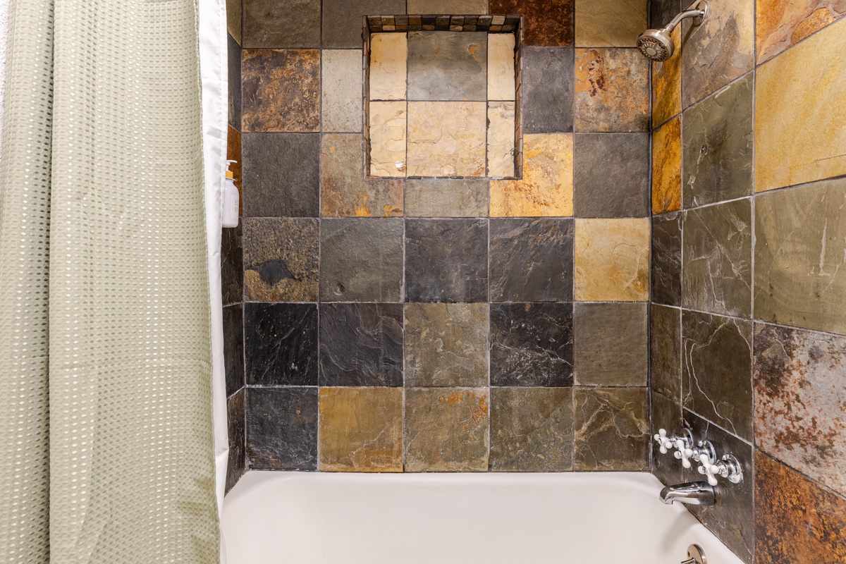 Indulge in a stunning slate-tiled shower for a refreshing escape!