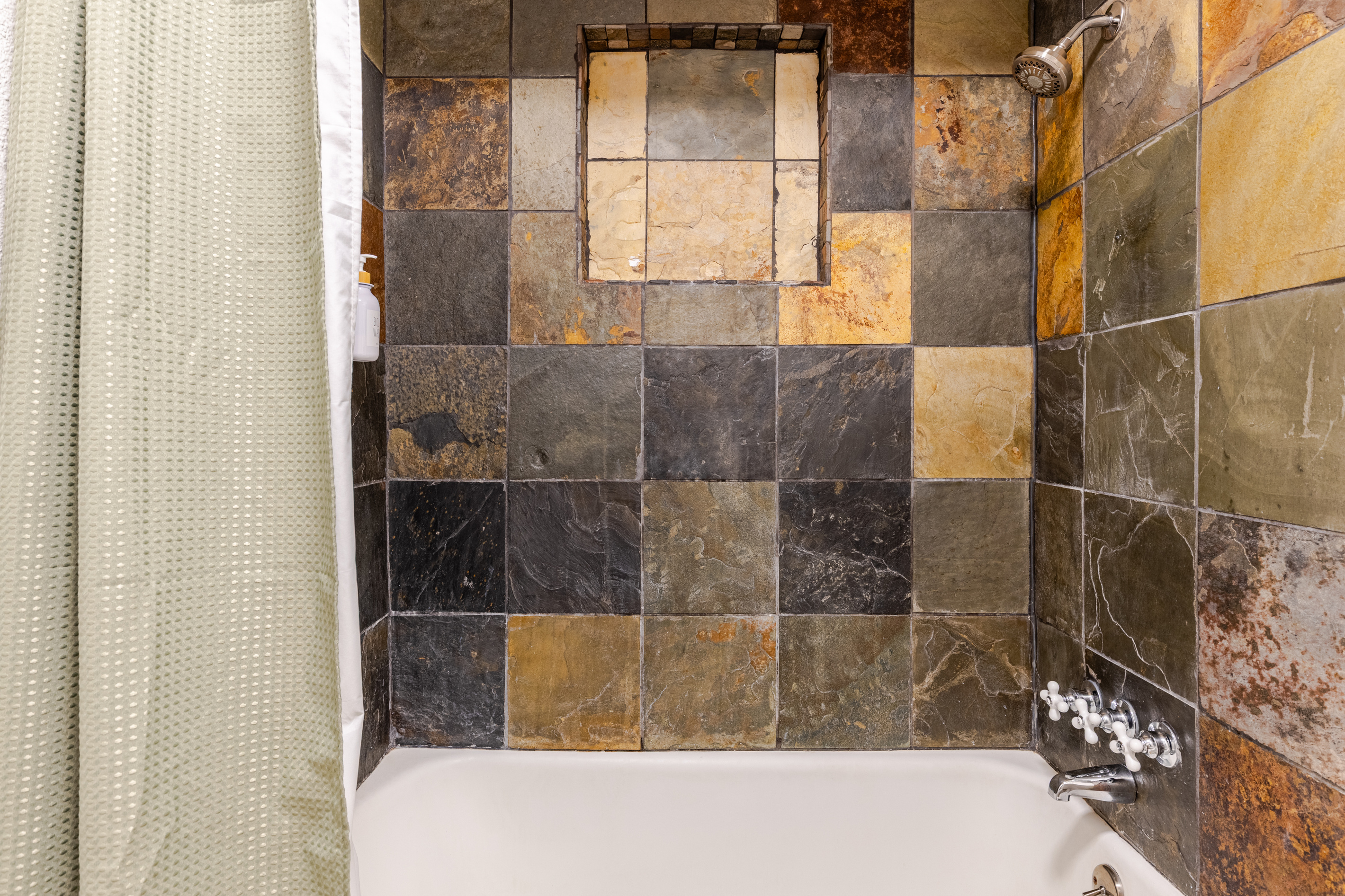 Indulge in a stunning slate-tiled shower for a refreshing escape!